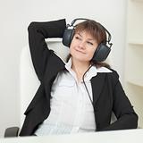 Young girl with big professional ear-phones on head sits in an a