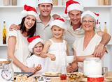 Children baking Christmas cakes in the kitchen with their family