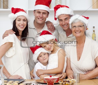 Smiling family baking Christmas cakes