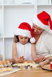Grandmother and little girl baking Christmas cakes