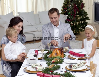 Father cutting a turkey in Christmas dinner