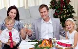 Parents toasting with wine in Christmas dinner