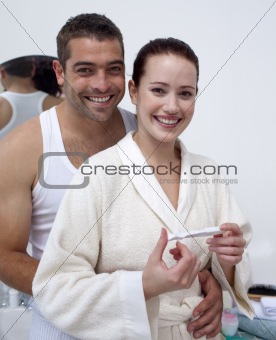Happy couple looking at a positive pregnancy test