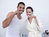 Couple cleaning their teeth in bathroom