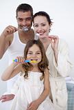 Family cleaning their teeth in bathroom