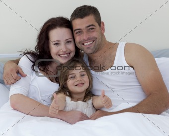 Smiling family playing in bed