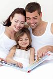 Young family reading in bed