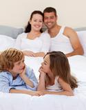 Brother and sister in bed with her parents