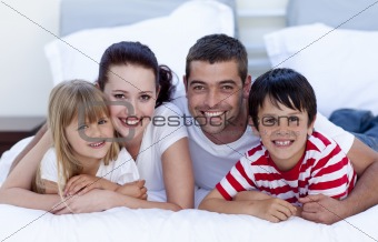 Smiling family lying in bed together