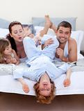 Parents and children having fun in bed