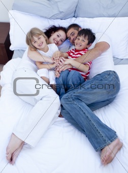 High view of parents and children relaxing in bed
