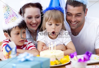 Little girl blowing out candles in her birthday