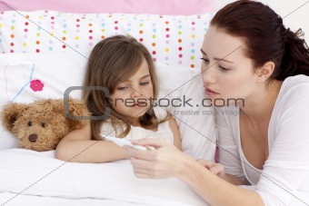 Mother taking sick daughter's temperature