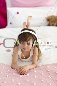 Smiling girl lying in bed listening to the music