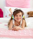 Smiling girl lying in bed listening to the music