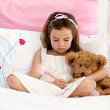 Little girl writing in bed