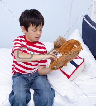 Little kid playing baseball in bed