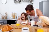 Little girl enjoying her breakfast with her father