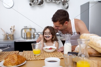 Little girl enjoying her breakfast with her father