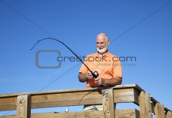 Senior Man Reels in Fish