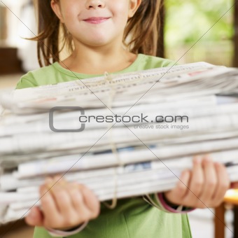 girl recycling newspapers
