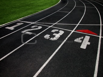 The Black Surface of a Cushioned Running Track with Marked Lanes