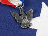 Close up of an Eagle Scout Award sitting on a Flag