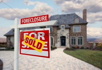 Sold Foreclosure Home For Sale Sign and House with Dramatic Sky Background.