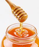 Honey dipper and full honey pot isolated on a white background