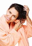 Smiling young woman drying hair with towel in a bathrobe  on a white background