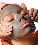 Beauty-spa. Applying of cosmetic mud mask. Close face of young woman
