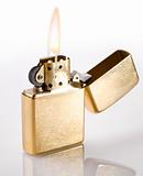 Flaming golden lighter on a white background