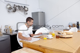 Man working in kitchen while having breakfast