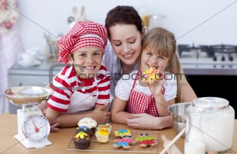 Smiling mother and children baking in the kitchen