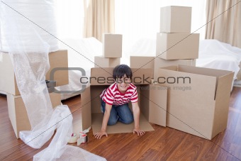 Kid playing with boxes in new house