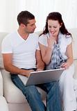 Portrait of couple buying online with a credit card on sofa