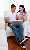 Couple buying online with a credit card on sofa