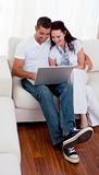 Couple using a laptop on sofa