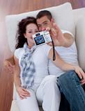Couple playing with a camera in living-room
