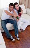 Couple having fun playing video games in living-room