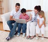 Family at home using a laptop