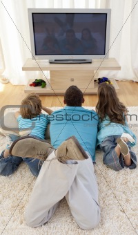 Family on floor in living-room watching television