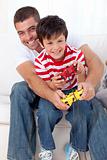 Smiling father and kid playing video games at home
