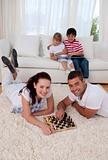 Couple playing chess on floor in living-room