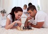 Couple playing chess on floor in living-room