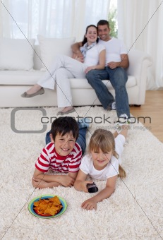 Happy children watching television on floor in living-room