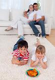 Brother and sister watching television on floor in living-room