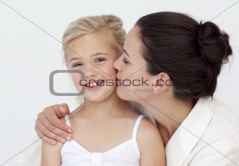 Mother kissing her daughter in bathroom