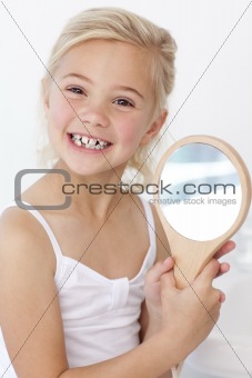 Little girl playing holding a mirror