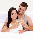 Lovers drinking champagne in bed